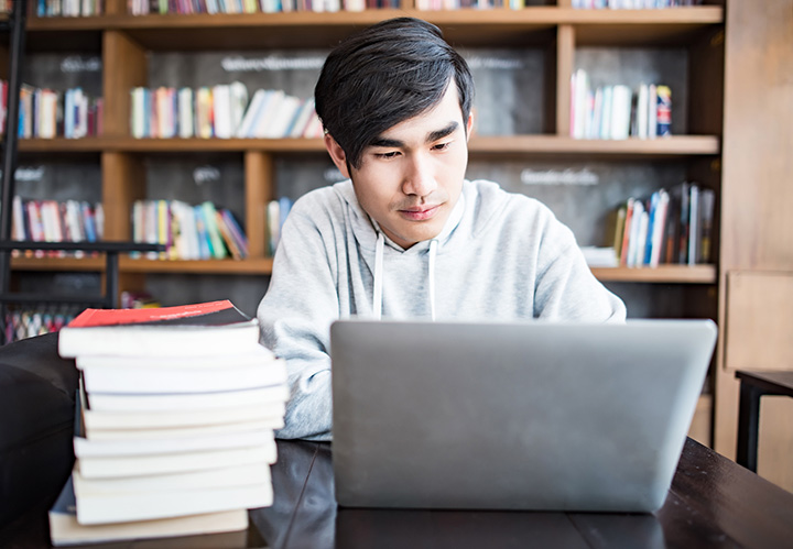 Man making APA style book citations on a laptop