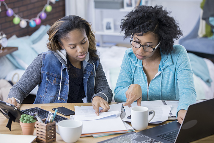 Girls looking at paper to make a Chicago style bibliography