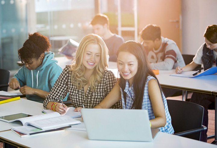 Women creating APA citation newspaper article on laptop