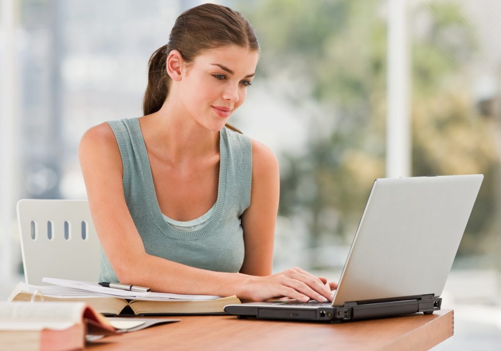 Woman creating dictionary citations on her laptop